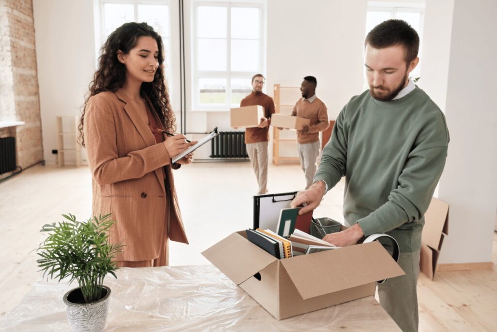 A man and woman are packing boxes together in a room, preparing for a move or organizing items.